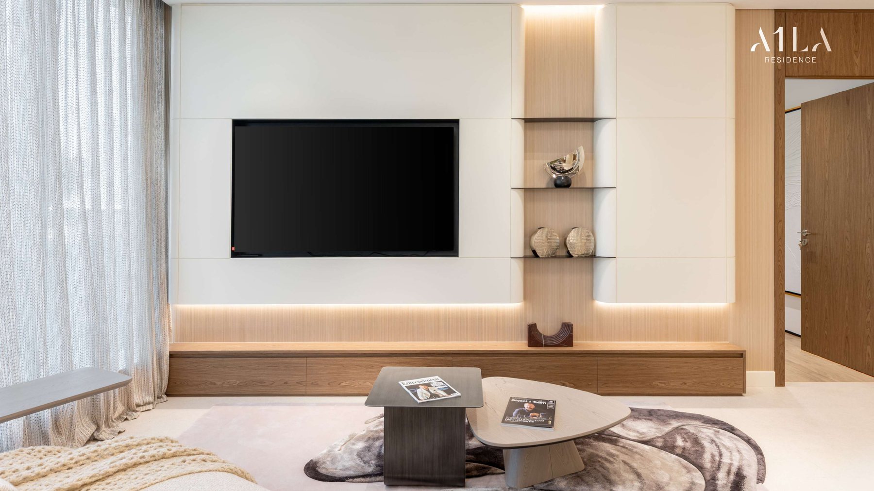 A living room at A1LA Residence with full-height curtains and a panelled media wall
