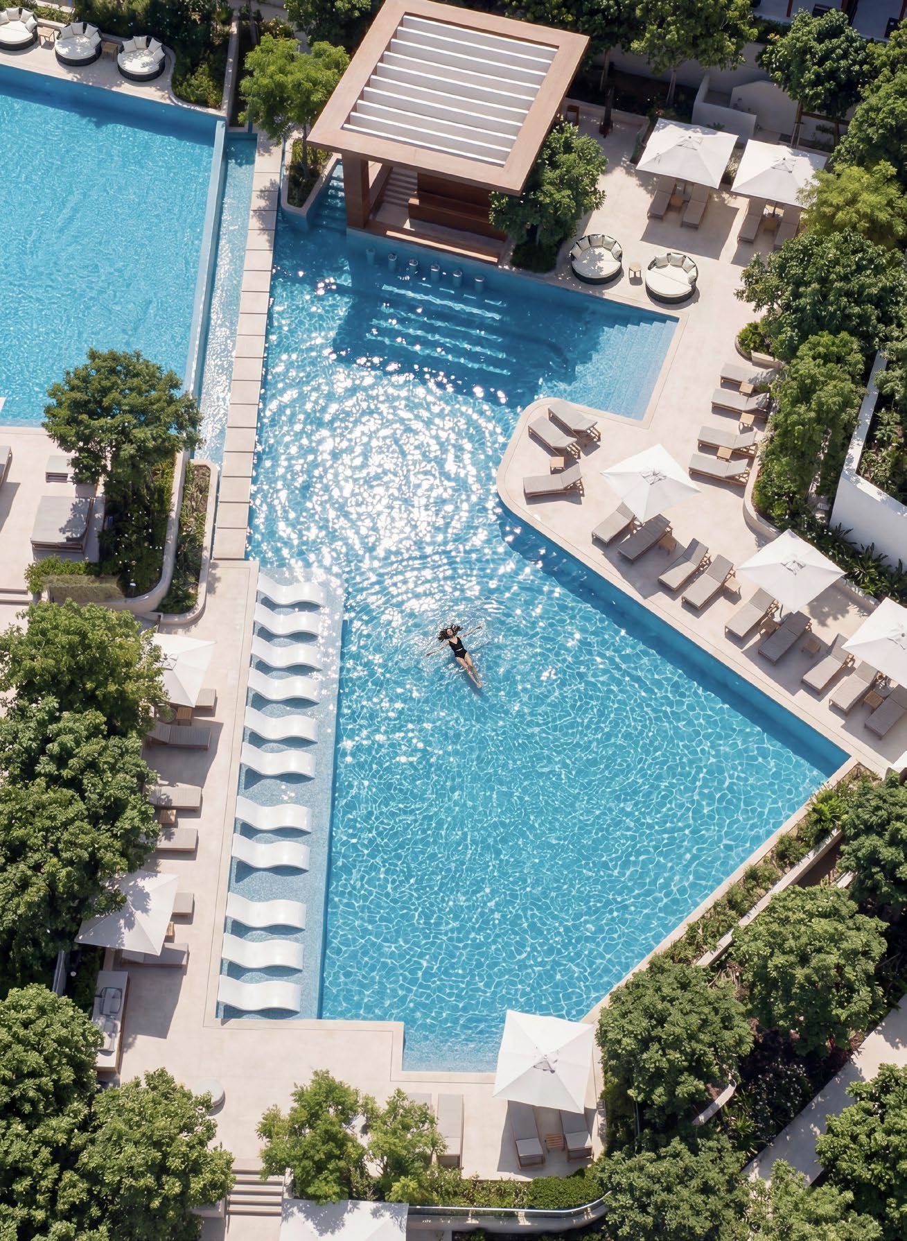 A large community pool with loungers, seen from above