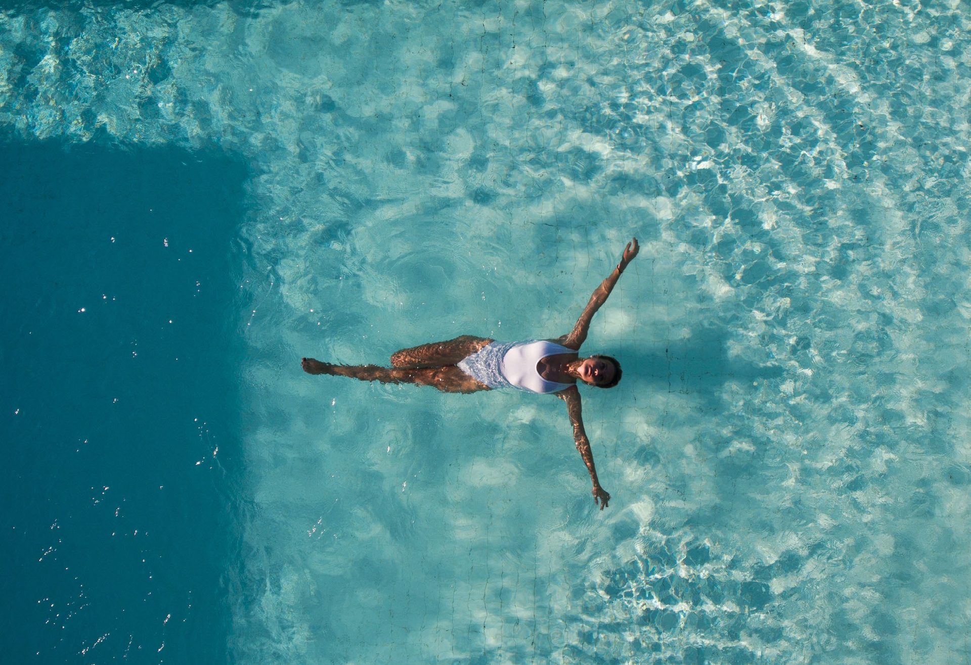 A swimmer in clear shallow water off the island